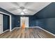 Spacious bedroom featuring stylish wood flooring, cool blue accent wall, ceiling fan and bright white trim at 115 Blue Ridge Trl, Powder Springs, GA 30127