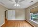 Comfortable bedroom featuring hardwood floors, a ceiling fan, and natural light from the window at 115 Blue Ridge Trl, Powder Springs, GA 30127