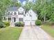 Charming two-story traditional home featuring a two-car garage, and a beautifully landscaped front yard at 115 Blue Ridge Trl, Powder Springs, GA 30127