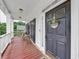 Cozy front porch featuring a 'Welcome-ish' sign on the door and wicker chairs on a covered porch at 115 Blue Ridge Trl, Powder Springs, GA 30127