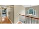 Hallway with hardwood floors, staircase, and a large window that provides natural light at 115 Blue Ridge Trl, Powder Springs, GA 30127