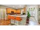 Bright kitchen features hardwood floors, light wood cabinets, stainless steel appliances, and breakfast bar with orange stools at 115 Blue Ridge Trl, Powder Springs, GA 30127