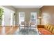 Comfortable seating area featuring a mustard sofa and chairs, with a view of the front door at 115 Blue Ridge Trl, Powder Springs, GA 30127