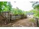View of the backyard with a rustic fence surrounding a pool area and lush green trees at 2923 Bicentennial Dr, Stone Mountain, GA 30087
