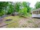 This home has a spacious and grassy backyard surrounded by lush trees and a wooden fence at 2923 Bicentennial Dr, Stone Mountain, GA 30087