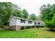 Charming single-story home with black shutters, a brick foundation and lush landscaping at 2923 Bicentennial Dr, Stone Mountain, GA 30087