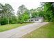 Charming single-story home with a long driveway, well-manicured lawn and lush, mature landscaping at 2923 Bicentennial Dr, Stone Mountain, GA 30087