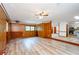 Open living room with wood paneling, new floors, and views to kitchen at 2923 Bicentennial Dr, Stone Mountain, GA 30087