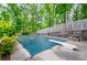 The in-ground pool is covered, and surrounded by mature trees, a wood fence and lush vegetation at 2923 Bicentennial Dr, Stone Mountain, GA 30087