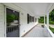 Inviting covered front porch with a storm door, offering a glimpse of the lush greenery outside at 2923 Bicentennial Dr, Stone Mountain, GA 30087