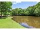 Scenic view of a pond surrounded by lush greenery, creating a tranquil and inviting atmosphere at 4586 Smoke Rise Ln, Marietta, GA 30062