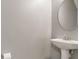 Bathroom with pedestal sink, oval mirror and visible toilet paper holder at 1406 Dolcetto Nw Trce # 13, Kennesaw, GA 30152