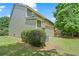 Side exterior of home with green siding, complemented by a well-maintained lawn and mature trees on a partly cloudy day at 1406 Dolcetto Nw Trce # 13, Kennesaw, GA 30152