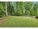 Expansive backyard featuring mature trees, a playset, and a storage shed, perfect for outdoor activities at 1767 Hunters Sw Trce, Lilburn, GA 30047