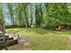 Spacious backyard showcasing a lush lawn, mature trees, and a charming storage shed at 1767 Hunters Sw Trce, Lilburn, GA 30047