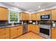 Bright kitchen with stainless steel appliances, granite counters, and wood cabinets and flooring at 1767 Hunters Sw Trce, Lilburn, GA 30047