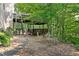 A stone and gravel backyard offers a wooden deck and staircase to an upper level at 2185 Arbor Chase, Cumming, GA 30041