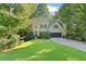 Charming home with lush green lawn, mature trees, and a welcoming two-car garage at 2185 Arbor Chase, Cumming, GA 30041