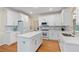 Bright, modern kitchen with white cabinetry, stainless steel appliances, and a spacious center island at 2185 Arbor Chase, Cumming, GA 30041