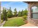 Green backyard features a lush lawn, landscaping and access from a brick patio, with a window view into the home at 3592 Parkhaven Pl, Brookhaven, GA 30319