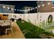 Night view of backyard with artificial turf, privacy fence, and string lights at 3811 Holliwell Pass, Cumming, GA 30040