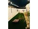 Night view of backyard with manicured artificial turf, games, string lights and fence at 3811 Holliwell Pass, Cumming, GA 30040