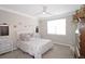 Neutral bedroom with a ceiling fan, large window, stylish decor, and a cozy bed with plenty of pillows at 3811 Holliwell Pass, Cumming, GA 30040