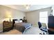 Bedroom with a bed, dresser, desk, ceiling fan, and a large window providing natural light at 3811 Holliwell Pass, Cumming, GA 30040