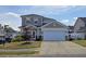Charming two-story home with a well-maintained lawn and attached two-car garage on a sunny day at 3811 Holliwell Pass, Cumming, GA 30040