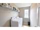 Bright laundry room with washer, dryer, shelving, and natural light at 3811 Holliwell Pass, Cumming, GA 30040