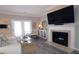 Cozy living room with a fireplace, mounted TV, hardwood floors, and patio access with plenty of natural light at 3811 Holliwell Pass, Cumming, GA 30040