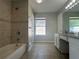 Bathroom with a tub and shower featuring tile walls and a window with natural light at 4081 Liberty Hill Dr, Norcross, GA 30093