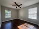 Bedroom featuring hardwood floors, ceiling fan, and two windows for natural light at 4081 Liberty Hill Dr, Norcross, GA 30093