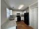 Updated kitchen with modern granite counters, black appliances, white cabinets, and tile flooring at 4081 Liberty Hill Dr, Norcross, GA 30093