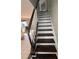 Traditional staircase with wooden treads and white risers, complemented by dark wood railing and tile flooring at 4081 Liberty Hill Dr, Norcross, GA 30093