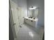 Bright bathroom features double sinks, white cabinetry, gray walls, and tile flooring at 955 Tributary Way, Dacula, GA 30019