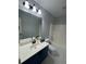 Bathroom features a large mirror, vanity with storage, and shower over tub at 955 Tributary Way, Dacula, GA 30019