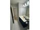 Bathroom features a large mirror, vanity with storage, tile floor and shower over tub at 955 Tributary Way, Dacula, GA 30019