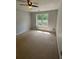 Bedroom featuring neutral carpet, fan, and window with a tree view at 955 Tributary Way, Dacula, GA 30019