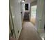 Hallway view featuring the staircase and entryway leading to a carpeted floor at 955 Tributary Way, Dacula, GA 30019