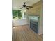 Enclosed porch with wood flooring has a fireplace and a ceiling fan at 955 Tributary Way, Dacula, GA 30019