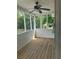 Enclosed porch with wood flooring, ceiling fan, and wooded view at 955 Tributary Way, Dacula, GA 30019