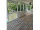 Enclosed porch with wood flooring overlooks green grass and a white fence at 955 Tributary Way, Dacula, GA 30019