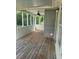 Enclosed porch with wood flooring and a ceiling fan overlooking a wooded area at 955 Tributary Way, Dacula, GA 30019