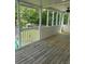 Enclosed porch with wood flooring, a ceiling fan, and white railings at 955 Tributary Way, Dacula, GA 30019