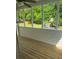 Enclosed porch with wood flooring overlooks the green, wooded backyard at 955 Tributary Way, Dacula, GA 30019