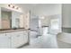 Bright bathroom with dual vanity, soaking tub, walk-in closet, and grey tile flooring at 203 Arabella Pkwy, Locust Grove, GA 30248