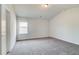 Bedroom features plush carpeting, a window offering natural light, and a neutral paint color at 203 Arabella Pkwy, Locust Grove, GA 30248