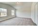 The primary bedroom features plush carpeting, ample natural light and neutral paint scheme at 203 Arabella Pkwy, Locust Grove, GA 30248