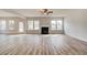 Spacious living room with a cozy fireplace, lots of natural light, and durable hardwood flooring at 203 Arabella Pkwy, Locust Grove, GA 30248